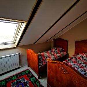 a attic bedroom with two beds and a window at Vila Gorocvet in Sremska Kamenica +27 photos