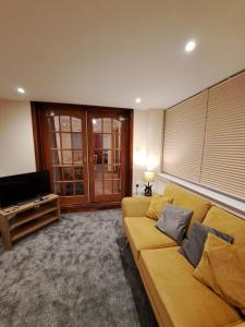 a living room with a couch and a flat screen tv at Leafield Holiday Home in Stranraer