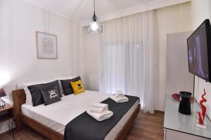 a bedroom with a bed and a flat screen tv at Antoine Apartment in Nea Peramos