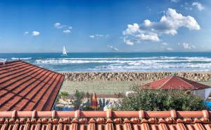 a view of the beach with a sailboat in the ocean at Viareggio sul Mare in Viareggio