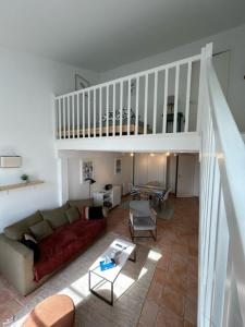 ein Wohnzimmer mit einem Sofa und einer Treppe in der Unterkunft Hom'Yeu in Port-Joinville