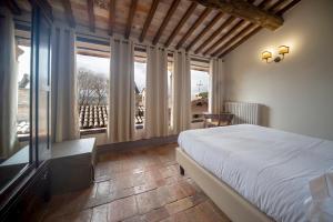 a bedroom with a bed and a large window at La Maestà antica dimora di campagna in Foligno