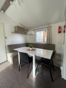 uma sala de jantar com uma mesa branca e cadeiras em Mobil Home de Marine em Port-la-Nouvelle