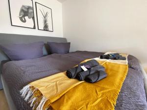 - un lit avec une couverture jaune au-dessus dans l'établissement Schölerberg Apartment mit Tiefgaragenparkplatz und Kingsize-Bett, à Osnabrück