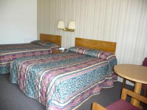 a hotel room with two beds and a table at Red Rose Motel in Elizabethtown