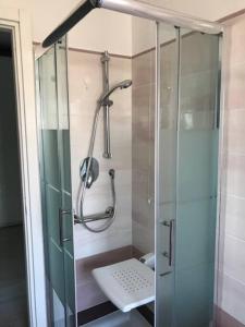 een douche met een glazen deur in de badkamer bij Appartamento sul mare (Ventimiglia/Bordighera) in Vallecrosia