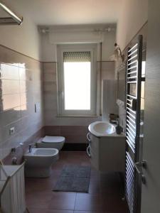 een badkamer met een toilet, een wastafel en een bad bij Appartamento sul mare (Ventimiglia/Bordighera) in Vallecrosia