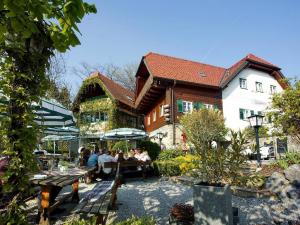 een groep mensen die aan tafels voor een gebouw zitten bij Stoffbauer GmbH in Graz