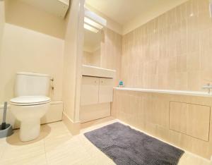 ein Badezimmer mit einem WC, einer Badewanne und einem Teppich in der Unterkunft Superbe appartement terrasse in Levallois-Perret