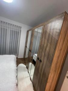 a bedroom with a large wooden cabinet next to a bed at Luxury Apartment in Gnjilane