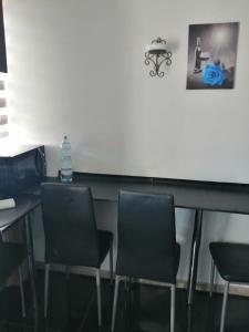 a bar with chairs and a bottle of water on a counter at Apartamenty na doby in Siedlce