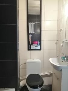 a bathroom with a black toilet and a sink at Apartamenty na doby in Siedlce