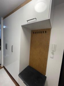 a room with a closet with white cabinets and a bench at Luxury Apartment in Gnjilane