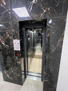 a glass elevator in a building with a mirror at Luxury Apartment in Gjilan