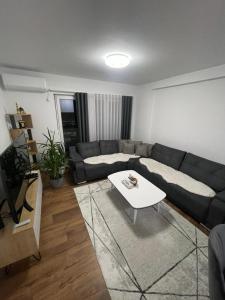 ein Wohnzimmer mit einem Sofa und einem Tisch in der Unterkunft Luxury Apartment in Gnjilane