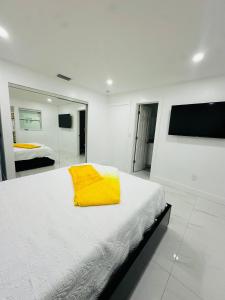 a white bedroom with a yellow blanket on a bed at Green planet in Naples