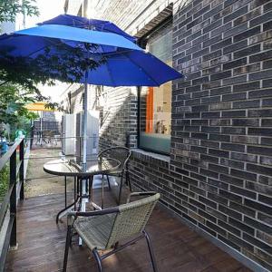 a table and chairs with a blue umbrella on a patio at private swimming pool near dasan beachroom in Namyangju