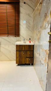 a bathroom with a sink and a stone wall at Farmhouse with pol near golf course road,Gurgaon in Gurgaon