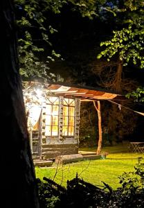 een klein huis in een tuin met een dak bij Gehele accommodatie met boshuisje en 3 woonwagens in Ranst