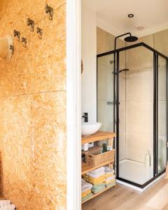 a bathroom with a glass shower and a sink at Gehele accommodatie met boshuisje en 3 woonwagens in Ranst