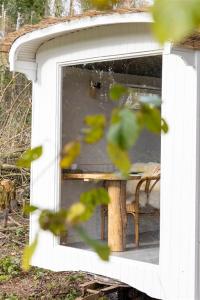 een spiegel met een reflectie van een tafel en een stoel bij Gehele accommodatie met boshuisje en 3 woonwagens in Ranst