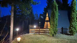 a church at night with lights in front of it at Cabane A-frame CeziAde Tihuta in Piatra Fantanele