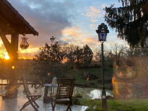 eine Katze, die neben einem Tisch und einer Straßenlaterne sitzt in der Unterkunft La Bastide in Armous-et-Cau