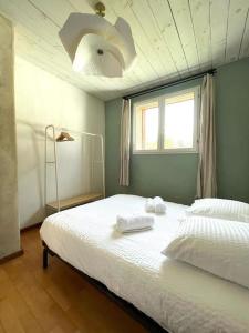 ein Schlafzimmer mit einem Bett mit zwei Handtüchern darauf in der Unterkunft Le cocon - Maison 2 chambres avec jardin - Tout à pied in Le Croisic