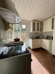 eine Küche mit weißen Schränken und einer Arbeitsplatte in der Unterkunft Le cocon - Maison 2 chambres avec jardin - Tout à pied in Le Croisic