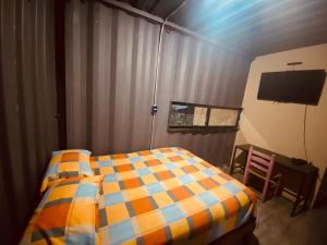 um quarto com uma cama e uma televisão em Container Manglar House em Nautla