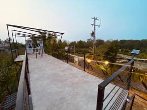 acovered walkway with a building on top of a field at Container Manglar House in Nautla