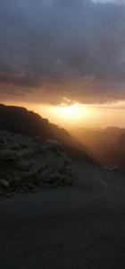 una puesta de sol en las montañas con la puesta de sol en Dana star en Ḑānā