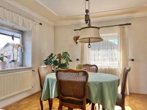 a dining room with a green table and chairs at Privathaus Sieglinde in Nußdorf