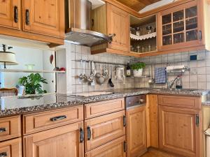a kitchen with wooden cabinets and granite counter tops at Privathaus Sieglinde in Nußdorf +22 photos