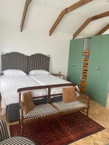 1 dormitorio con cama y banco. en * Couples and family secluded getaway + pool*, en Ciudad del Cabo