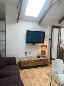 sala de estar con sofá y TV de pantalla plana en * Couples and family secluded getaway + pool* en Ciudad del Cabo