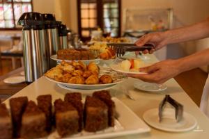una persona está poniendo un plato de comida en una mesa en Eco Hotel Oceanomare, en Florianópolis