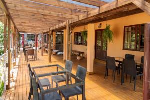 un patio con mesas y sillas en una terraza de madera en Eco Hotel Oceanomare, en Florianópolis