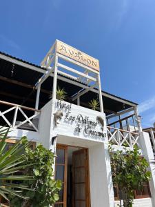 a white building with a sign for a restaurant at Delfines de Chicama Hotel in Puerto Chicama