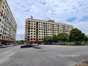 un grand bâtiment avec des voitures garées dans un parking dans l'établissement Serene Bukit Beruang Cottage 4 ROOMS FULL AIRCOND & NETFLIX by EZYROOM MELAKA, à Ayer Keroh