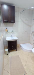 La salle de bains est pourvue d'un lavabo, d'une baignoire et de toilettes. dans l'établissement Apartamenty Jagiełło, à Zamość