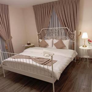 a bedroom with a white bed with a metal headboard at The Boutique Hotel Amman in Amman