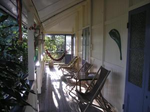 una veranda con sedie e tavolo su una casa di Mango tourist Hostel a Hervey Bay