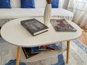 - une table blanche avec des magazines et un livre dans l'établissement Kristi Apartment, à Saranda