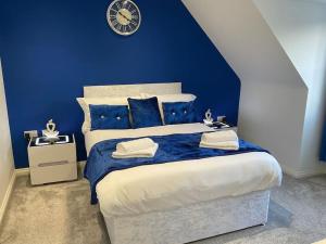 a blue bedroom with a large bed with blue walls at The WestField in Liversedge