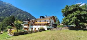 ein großes Haus auf einem Hügel auf einem Feld in der Unterkunft Apart Sonnenheim in Kaunertal