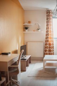 an office with a desk and a table and a window at Bel appartement au calme avec parking in Lyon