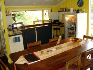 een keuken met een houten tafel en een koelkast bij Mango tourist Hostel in Hervey Bay