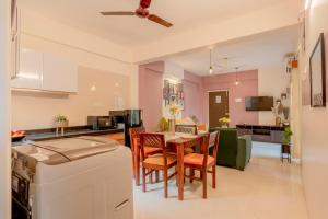 a kitchen and living room with a table and chairs at Bellini, Anjuna, Goa, 5 Mins from Beach, Centrally Located in Anjuna