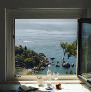 duże okno z widokiem na ocean w obiekcie B&B La Bergerie w Taominie
